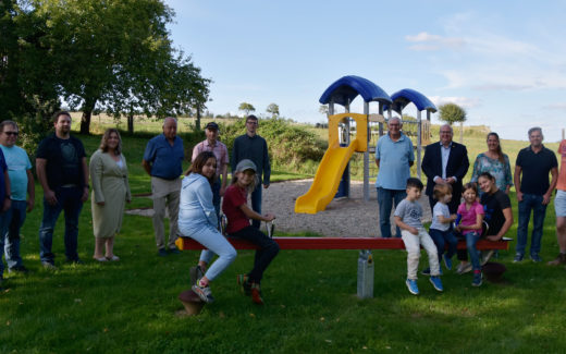 Gruppenbild bei der Spielplatz-Einweihung in Fischbach mit Ortsbeirat, Elterninitiative, Förderverein und einigen Kindern zusammen mit Bürgermeister Stephan Paule und Mitarbeiter des städtischen Bauhofes.